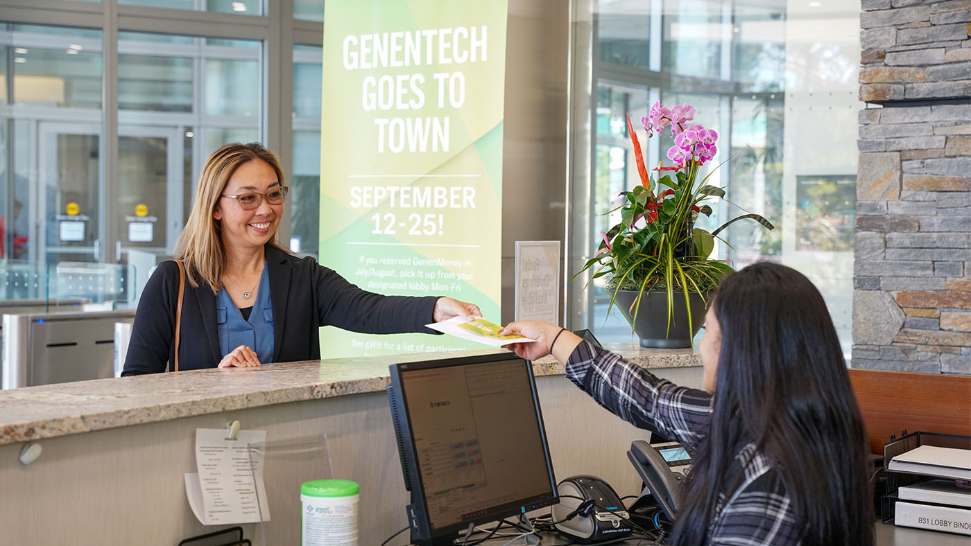A Genentech employee picks up GenenMoney to use at participating local merchants during Genentech Goes to Town 2022.