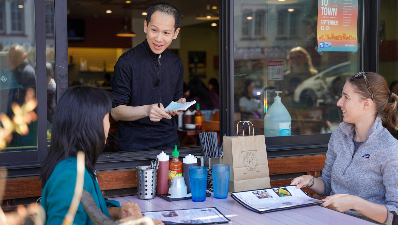 Two Genentech employees place their orders while sitting outside at Ben Tre, a Vietnamese restaurant in downtown SSF.